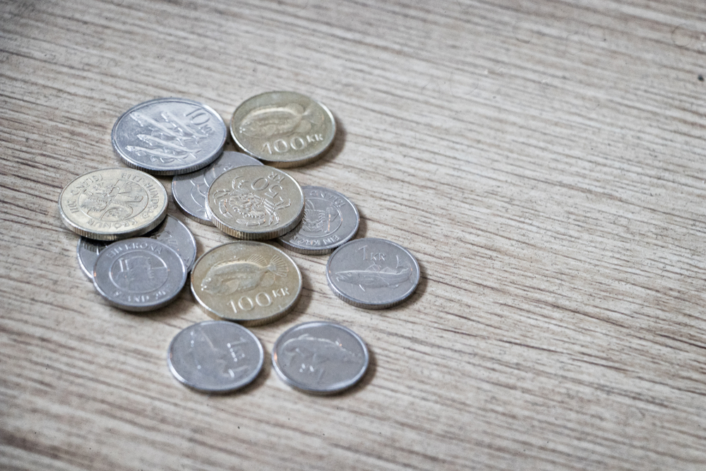 Íslenskar krónu myntar á viðarborði