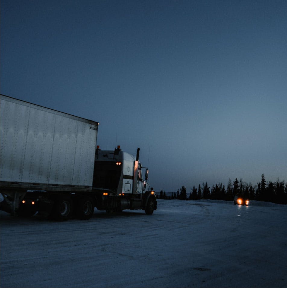 En semitrailer lastbil i ett vidöppet landskap är på väg till en leverans destination.