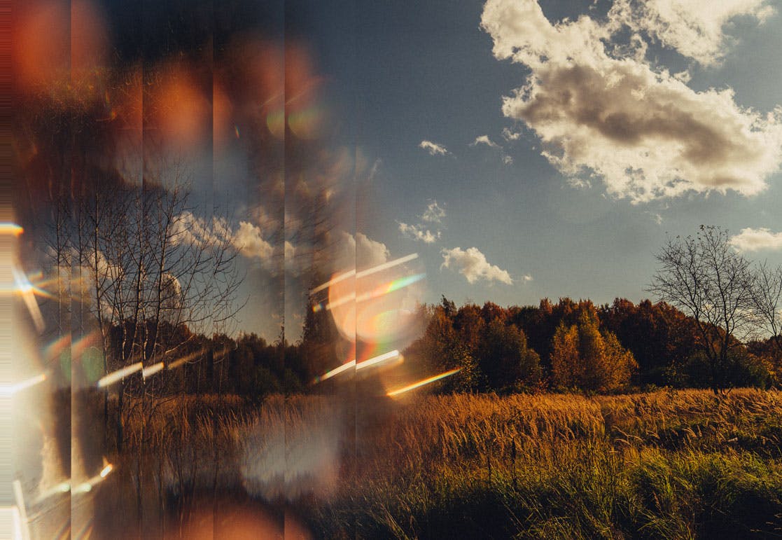Light is shattered through the lens on a rural landscape, with subtle rainbow effects.