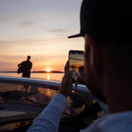 A man photographing the sunset at sea