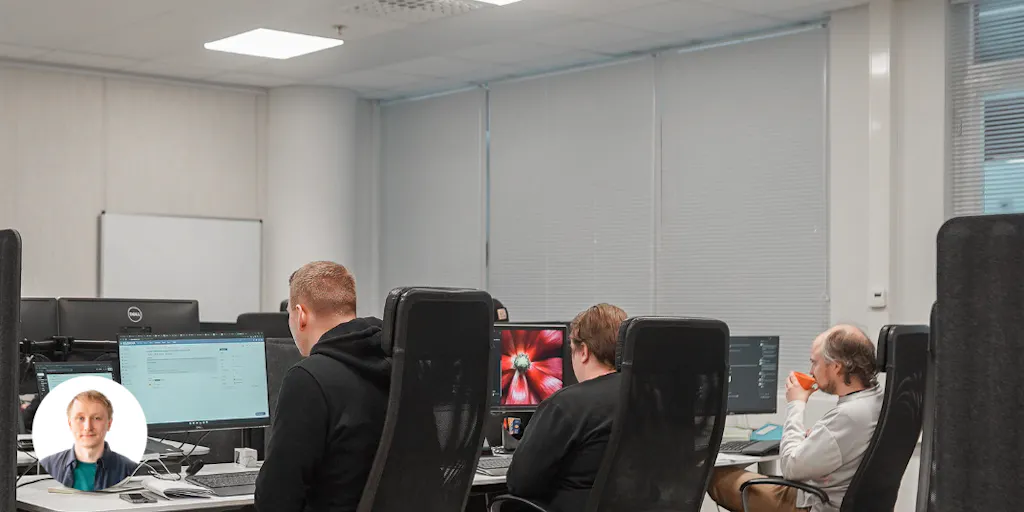 Ohjelmistokehittäjät istuvat rivissä tietokoneidensa ääressä. Yksi heistä hörppää juuri kahvia. Onni Keiskosken profiilikuva vasemmassa alareunassa.