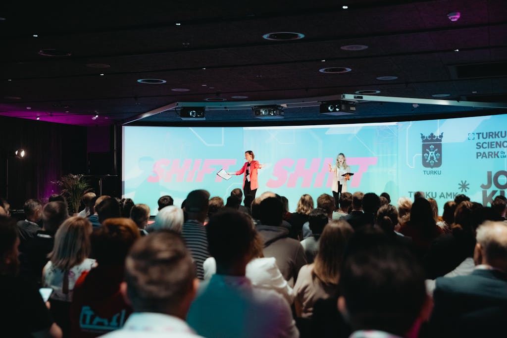 Puhuja pitämässä esitystä bisnesfestivaaleilla isolle yleisölle.