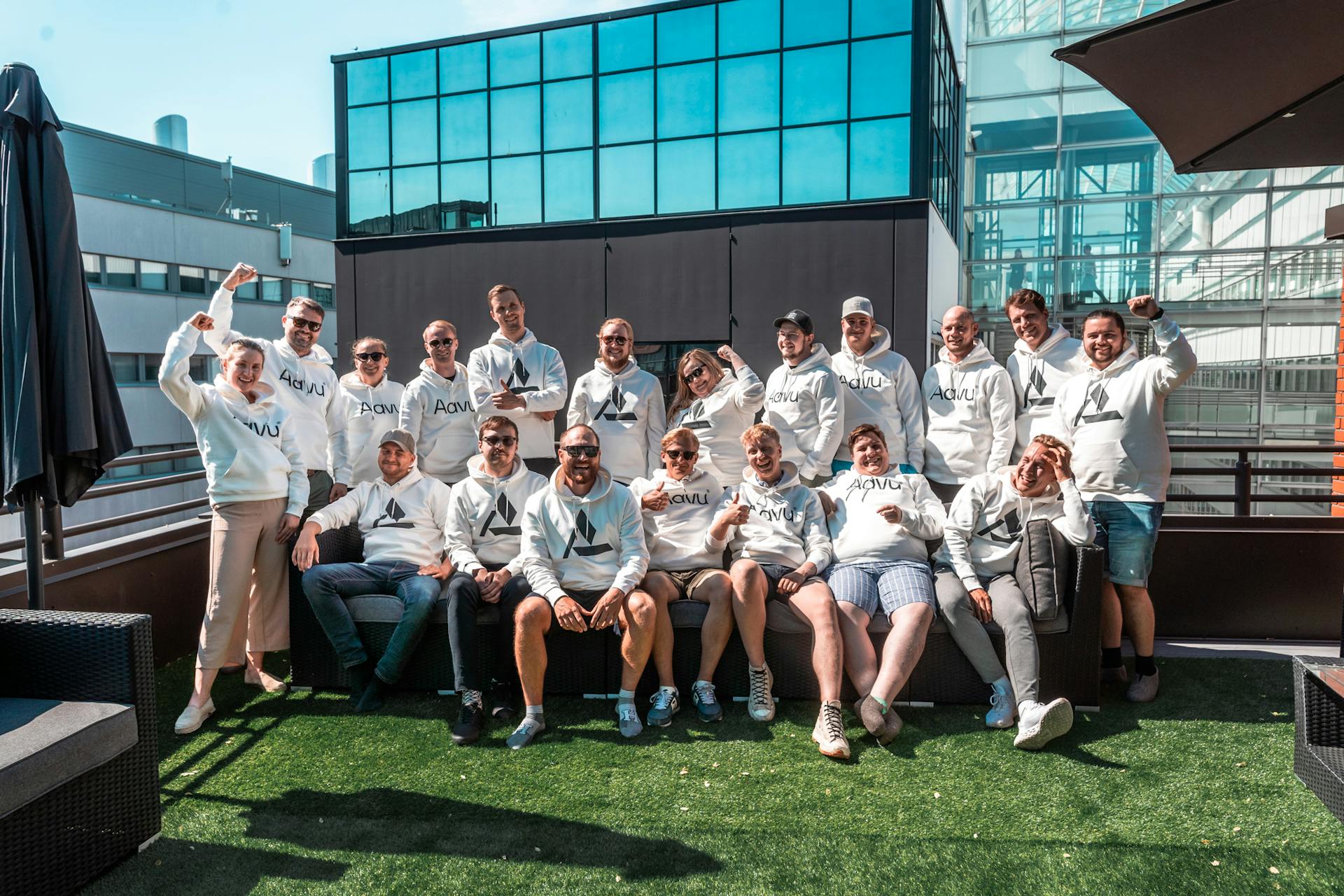 A group of 20 people of people smiling at a camera.