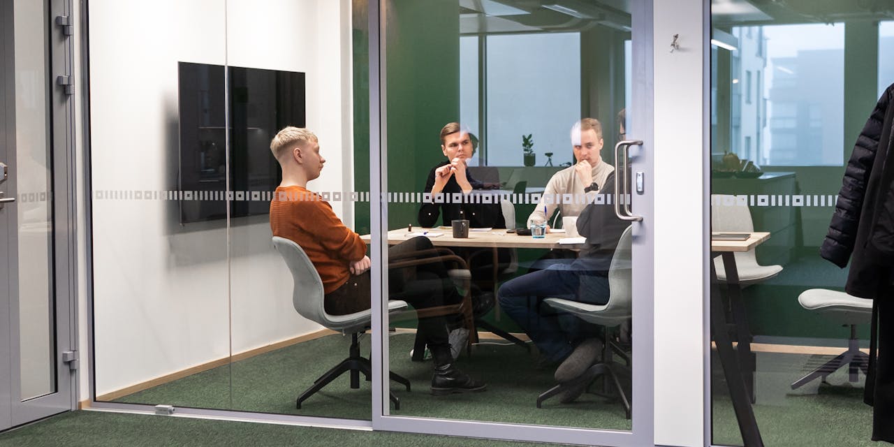 3 men sitting in a meeting room