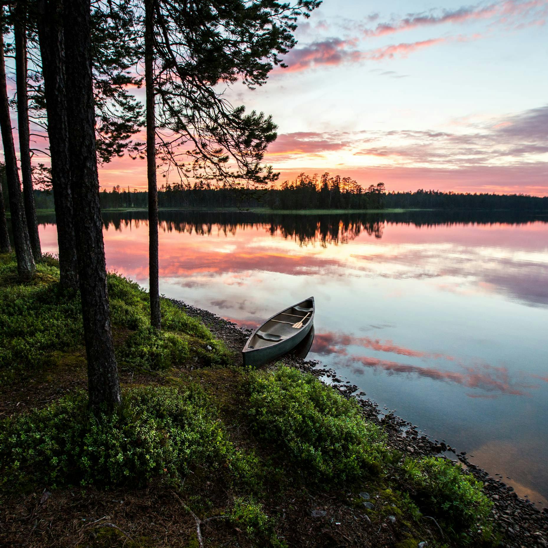 Canoe on the shore of a lake in Finnish nature at sunset
