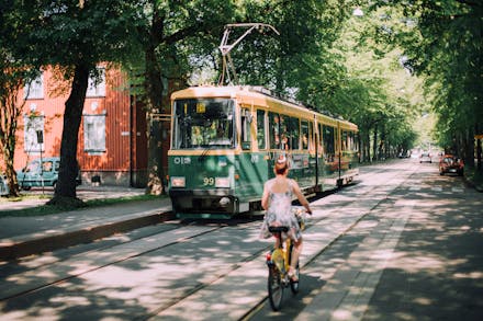 A picture of a tram and a woman on a bicycle in Helsinki