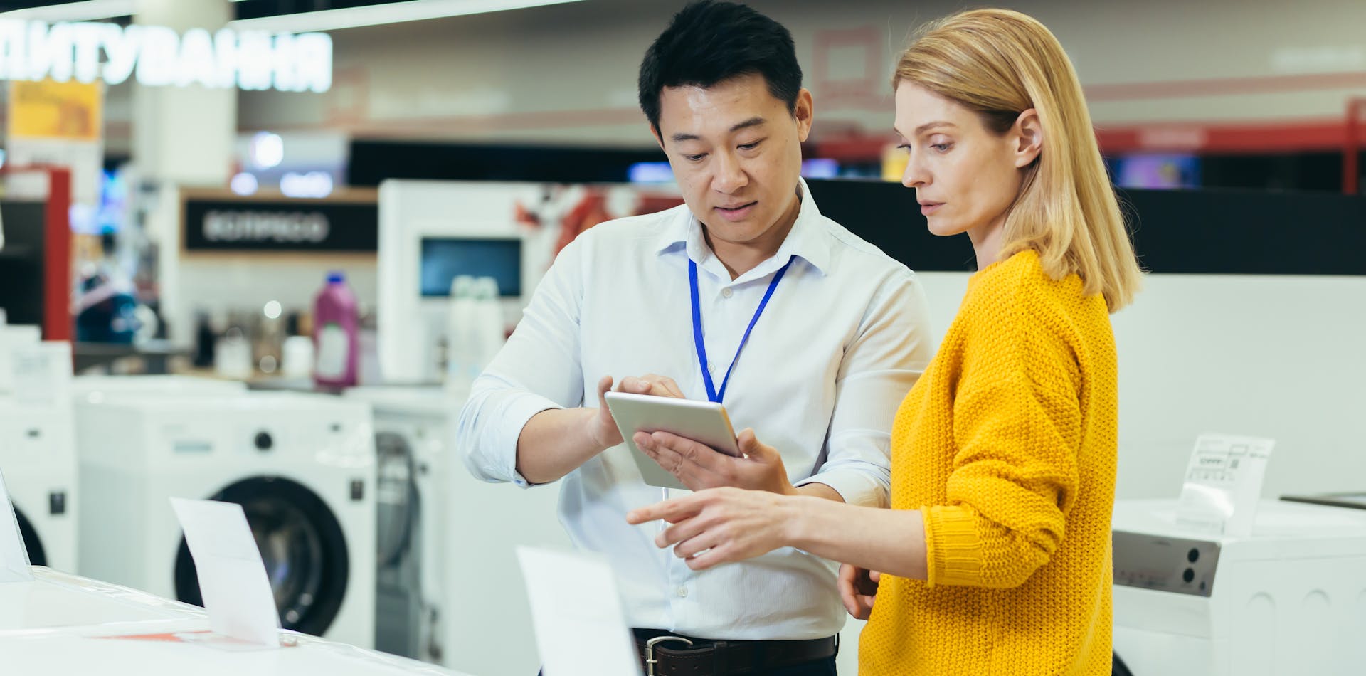 Salesperson using a tablet to assist a customer shop