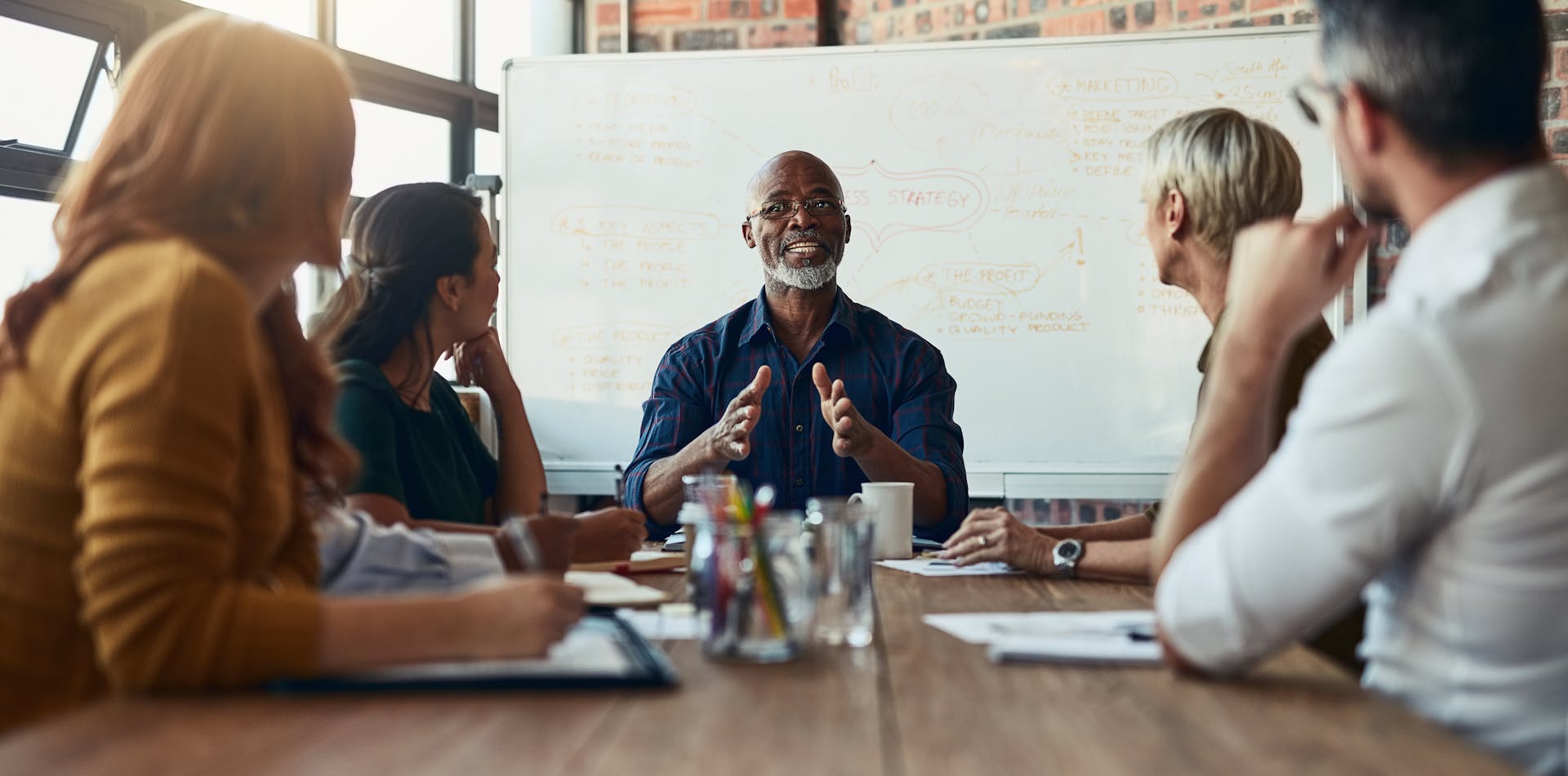 Man leading team AI workshop at table in conference room