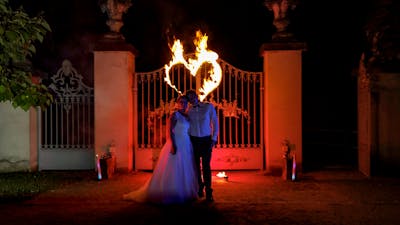 Brautpaar bei Feuershow vor brennendem Herzen.