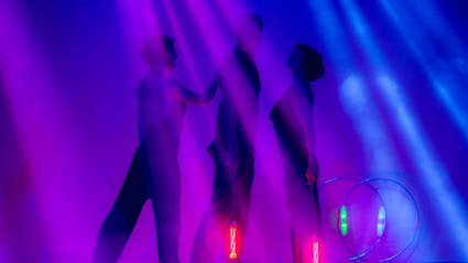 3 Performer with light tools on an illuminated stage.