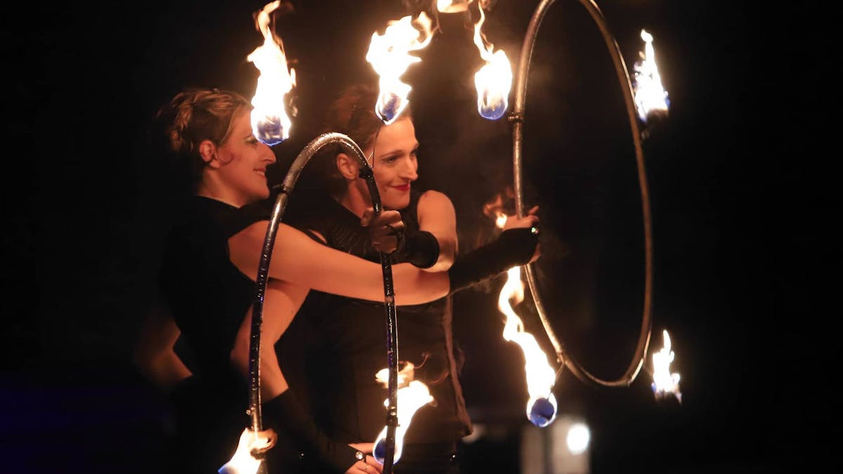 Twins at a fireshow with fire hula-hoops.