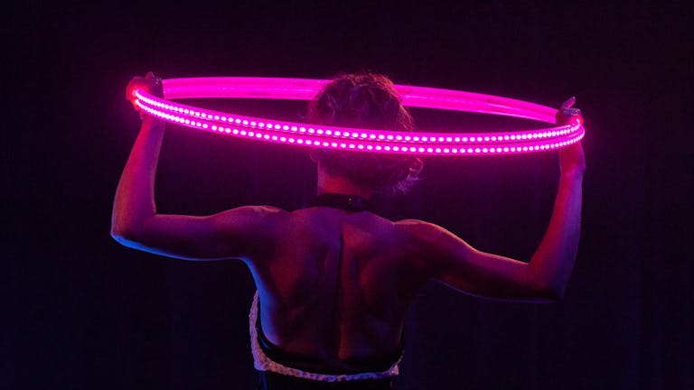 Showact mit vier leuchtenden LED-Multi-Hoops um den Körper der Artistin. 