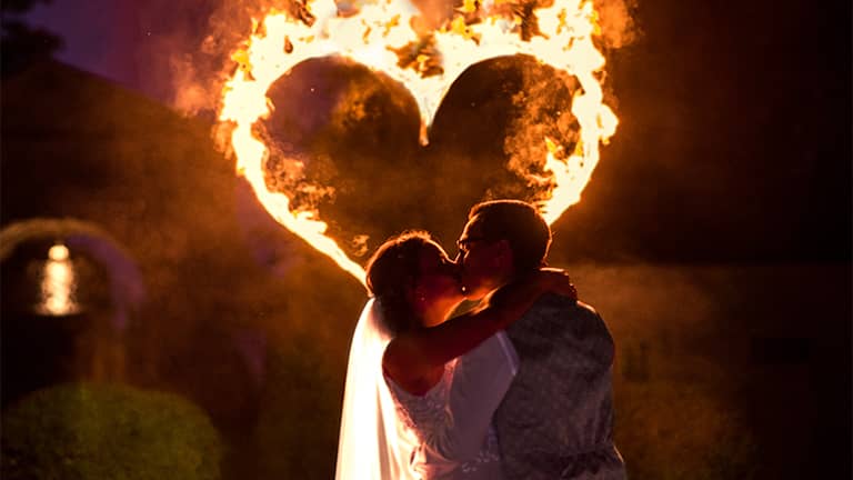 Feuershow auf Hochzeit mit brennendem Feuerherz und Feuerspieler.
