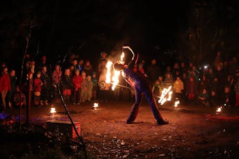 Feuerschlucker bei einer Feuershow vor Kindern bei einem Lichterfest.