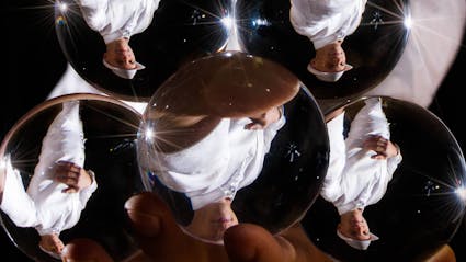 Spiegelung des Kontaktjongleurs in fünf Kristallkugeln.