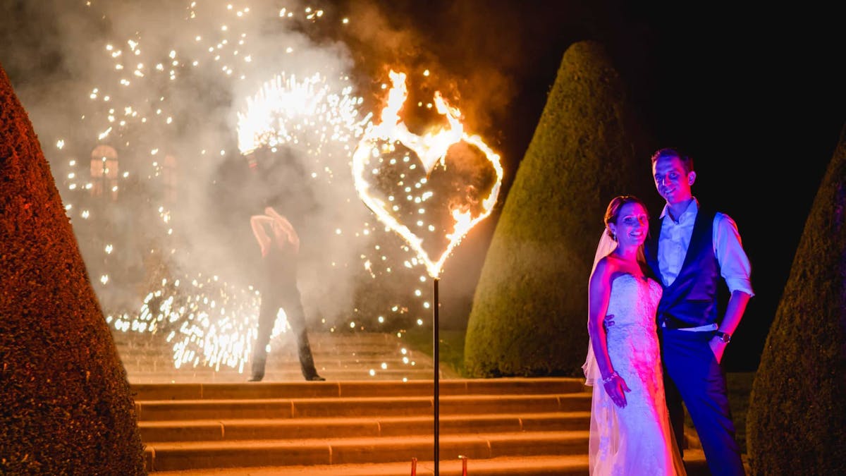 Feuershow auf Hochzeit mit brennendem Feuerherz und Feuerspieler.