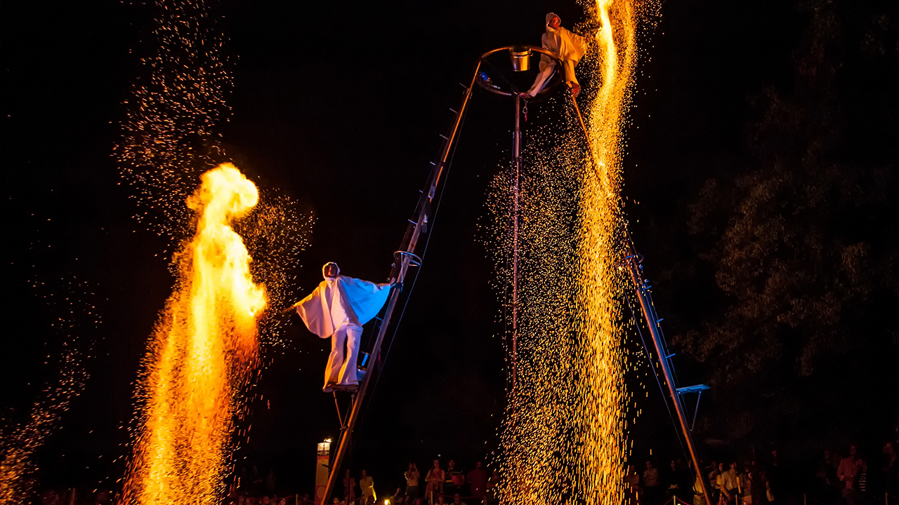 Fire performer creating big spark effects on an aerial rig