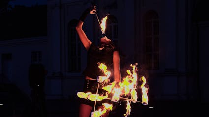 Performer extinguishing firepoi with her mouth. 