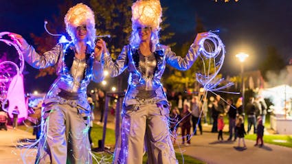 Licht-Walkact auf Stelzen auf einem Stadtfest. 