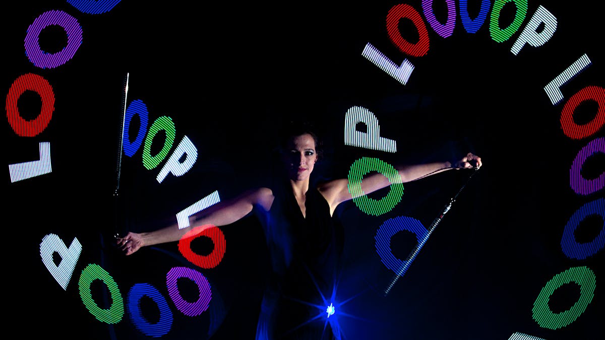 Artistin spielt LED-Pixelpoi mit LOOOOP Logo.