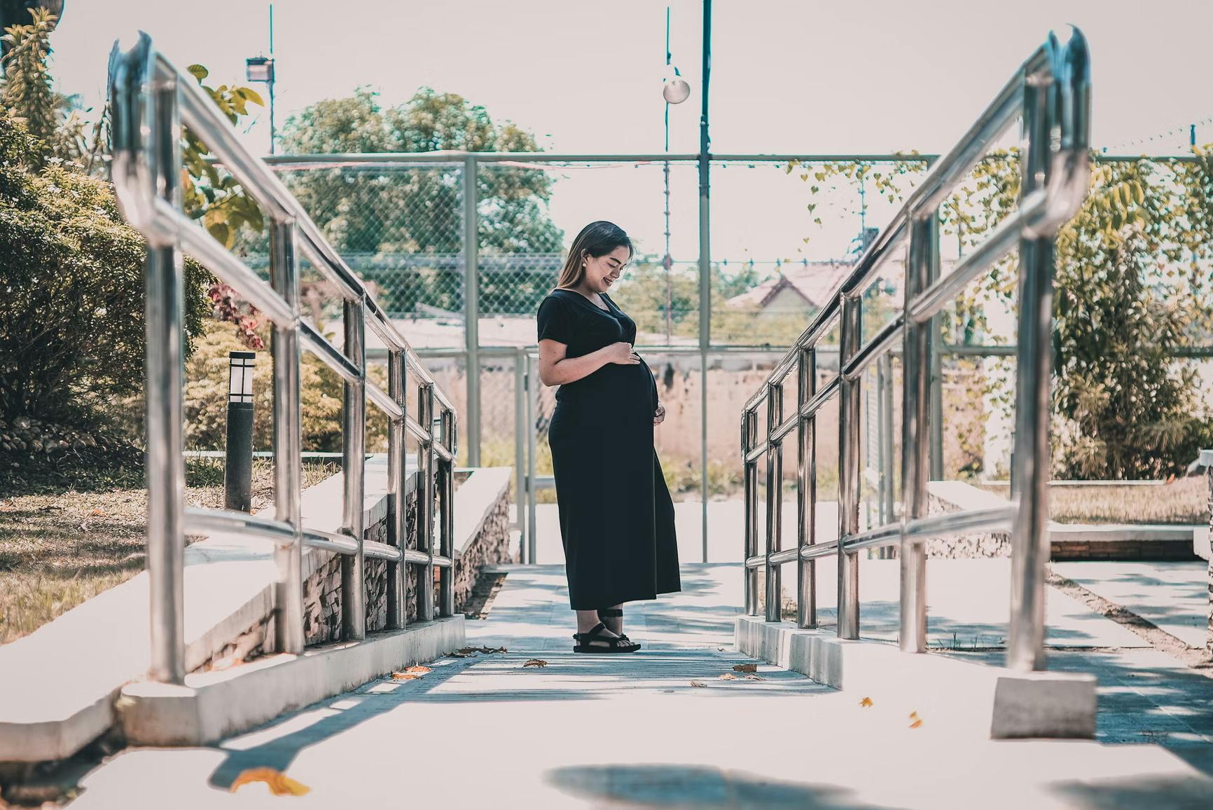woman in black dress standing on a walkway