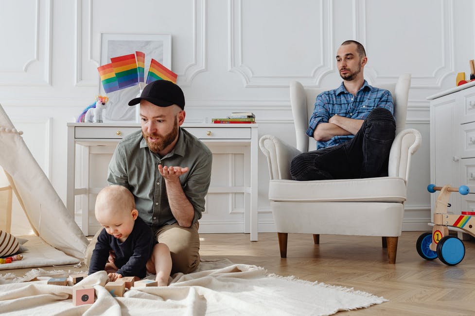 two men playing on the floor with their baby