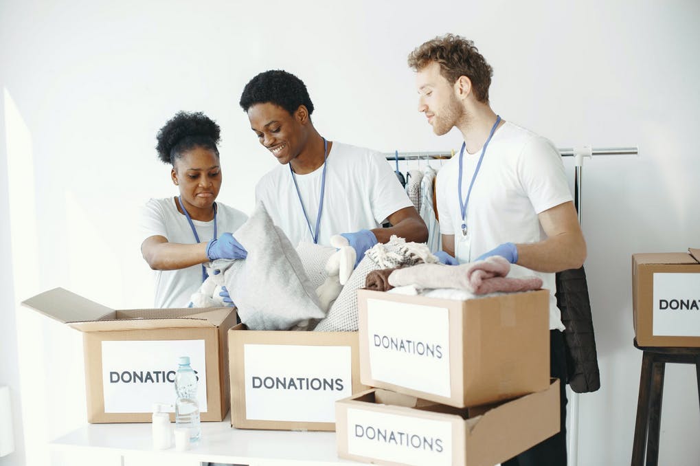 group of volunteers standing over donation boxes