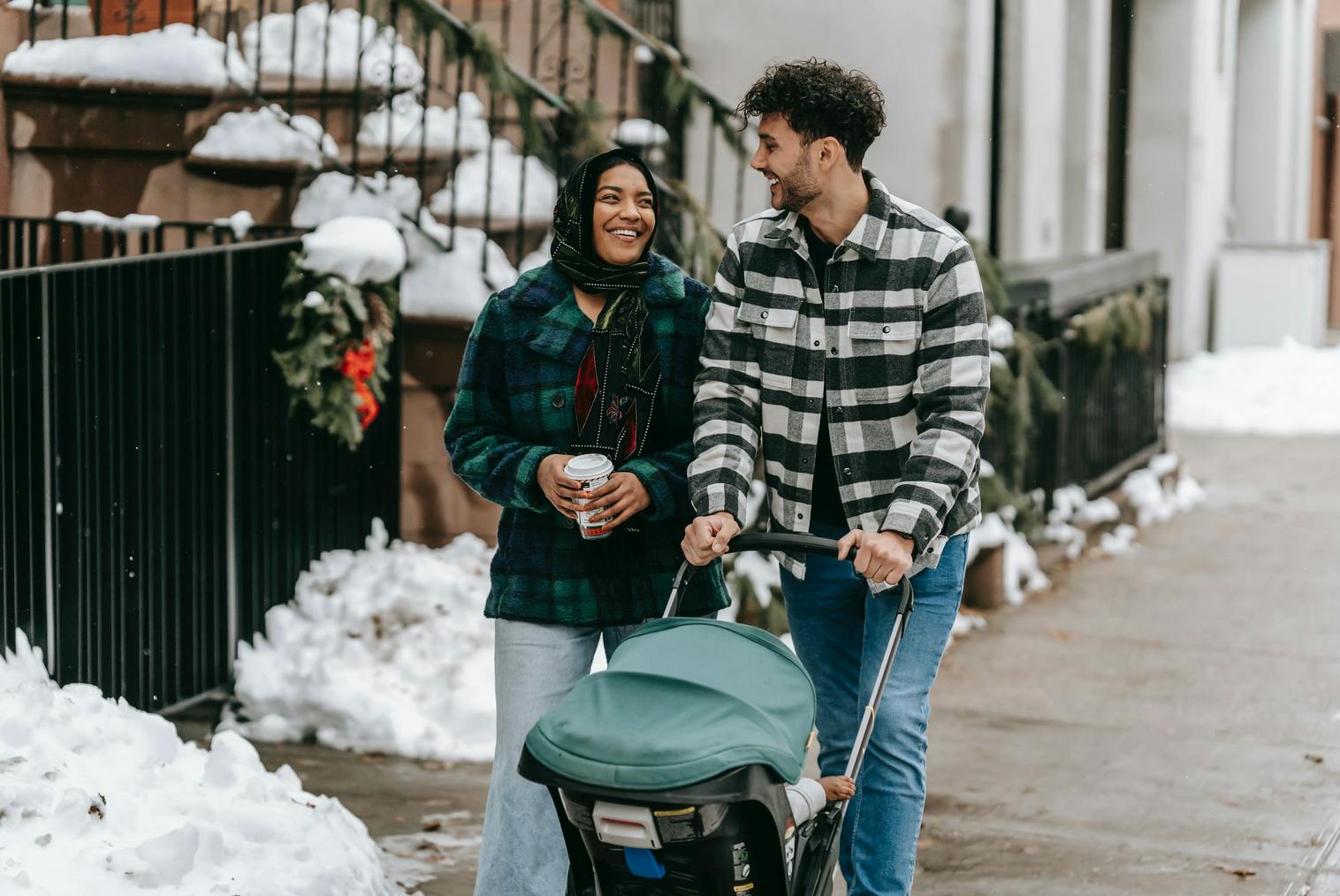 man and woman walking in the city with baby stroller