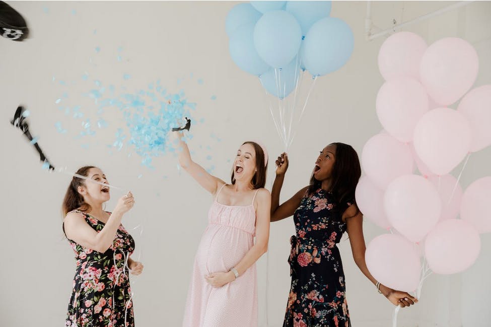 pregnant woman with balloons celebrating her baby shower