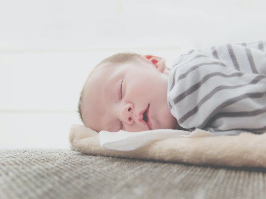 baby sleeping on a mat