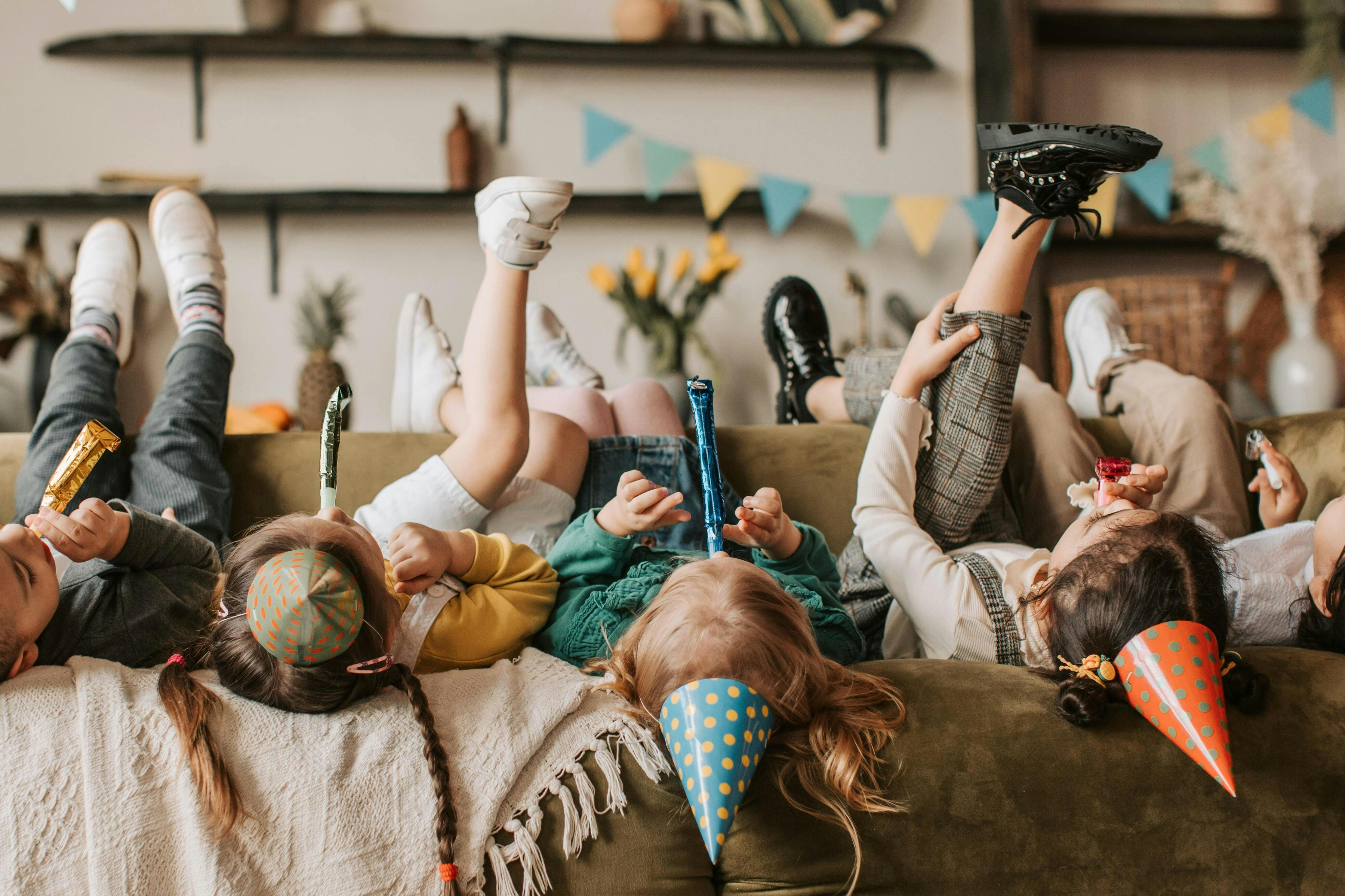 children with party hats on the couch