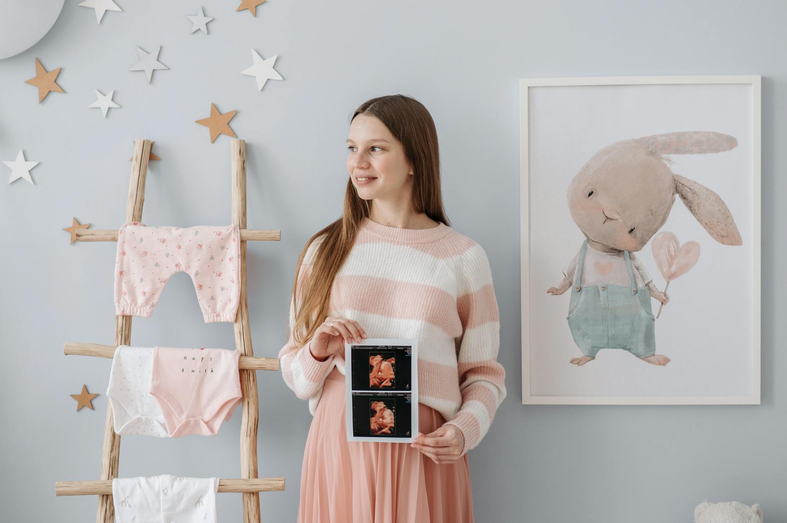 a mom holding a photo of her baby in a nursery