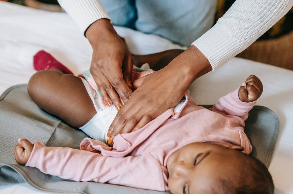 a baby receiving a massage and a diaper change