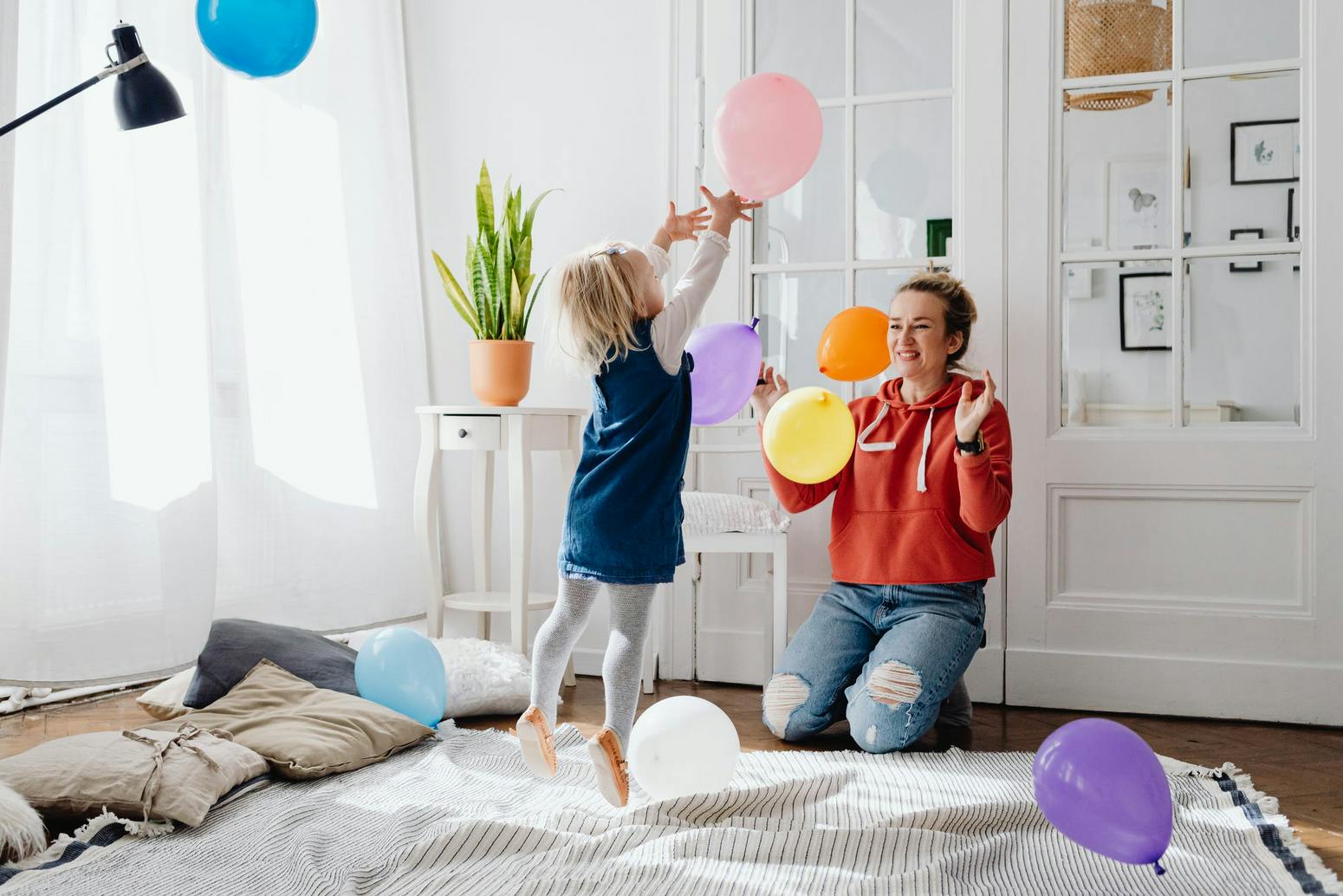 mom and toddler playing with balloons in a store