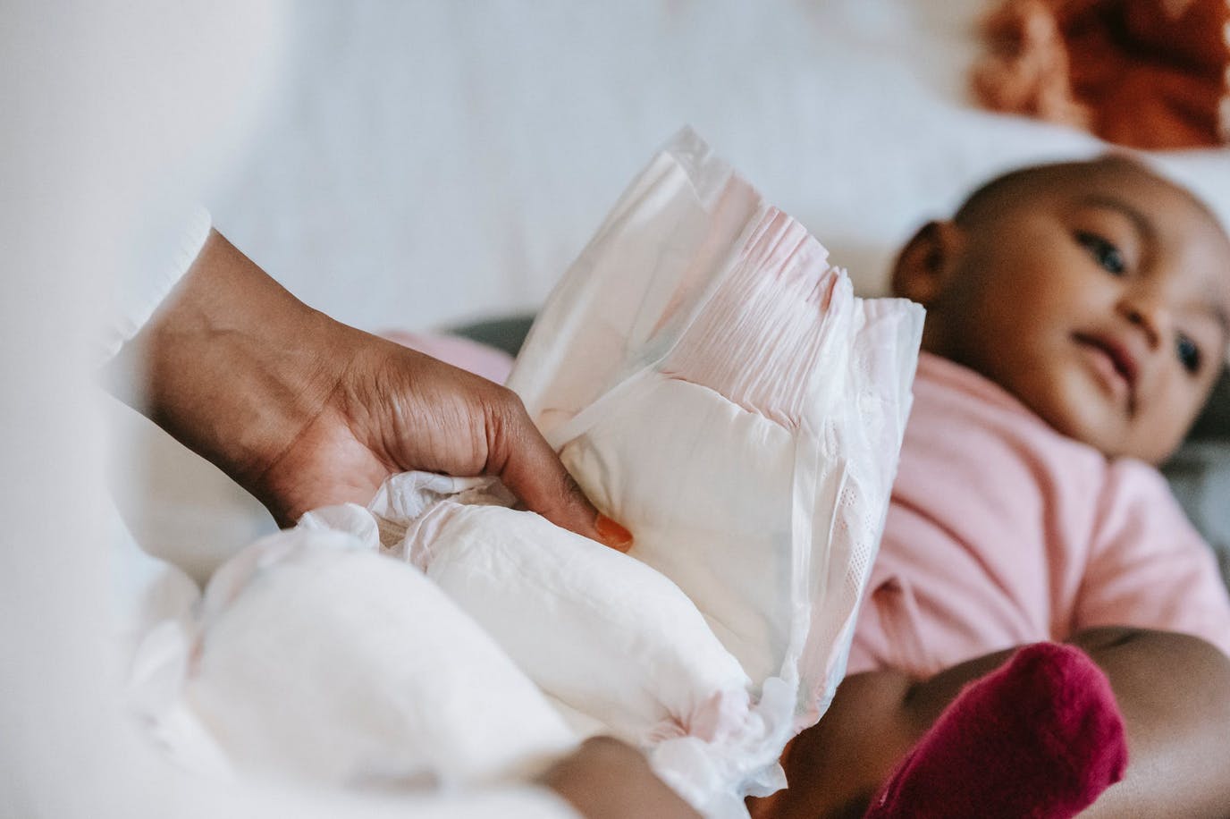 baby laying on back getting her diaper changed