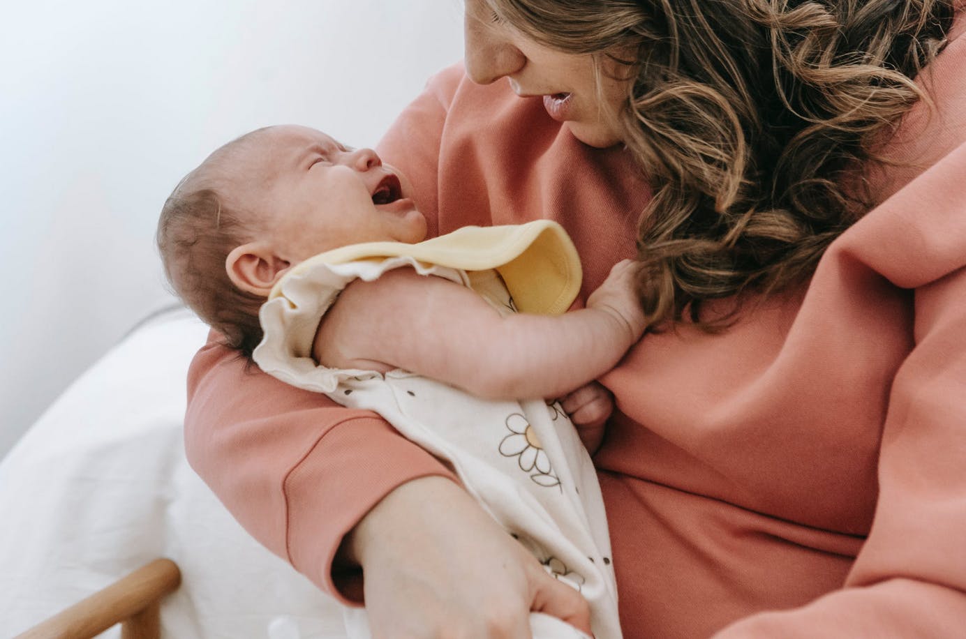 baby crying in her mother's arms with gas