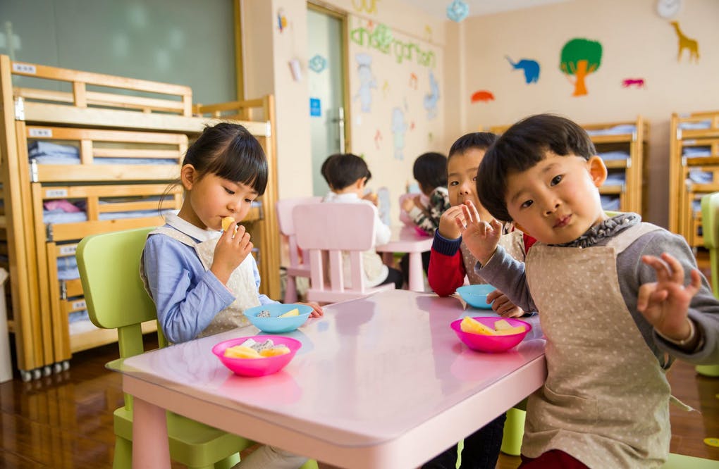 three children enjoying a snack during daycare