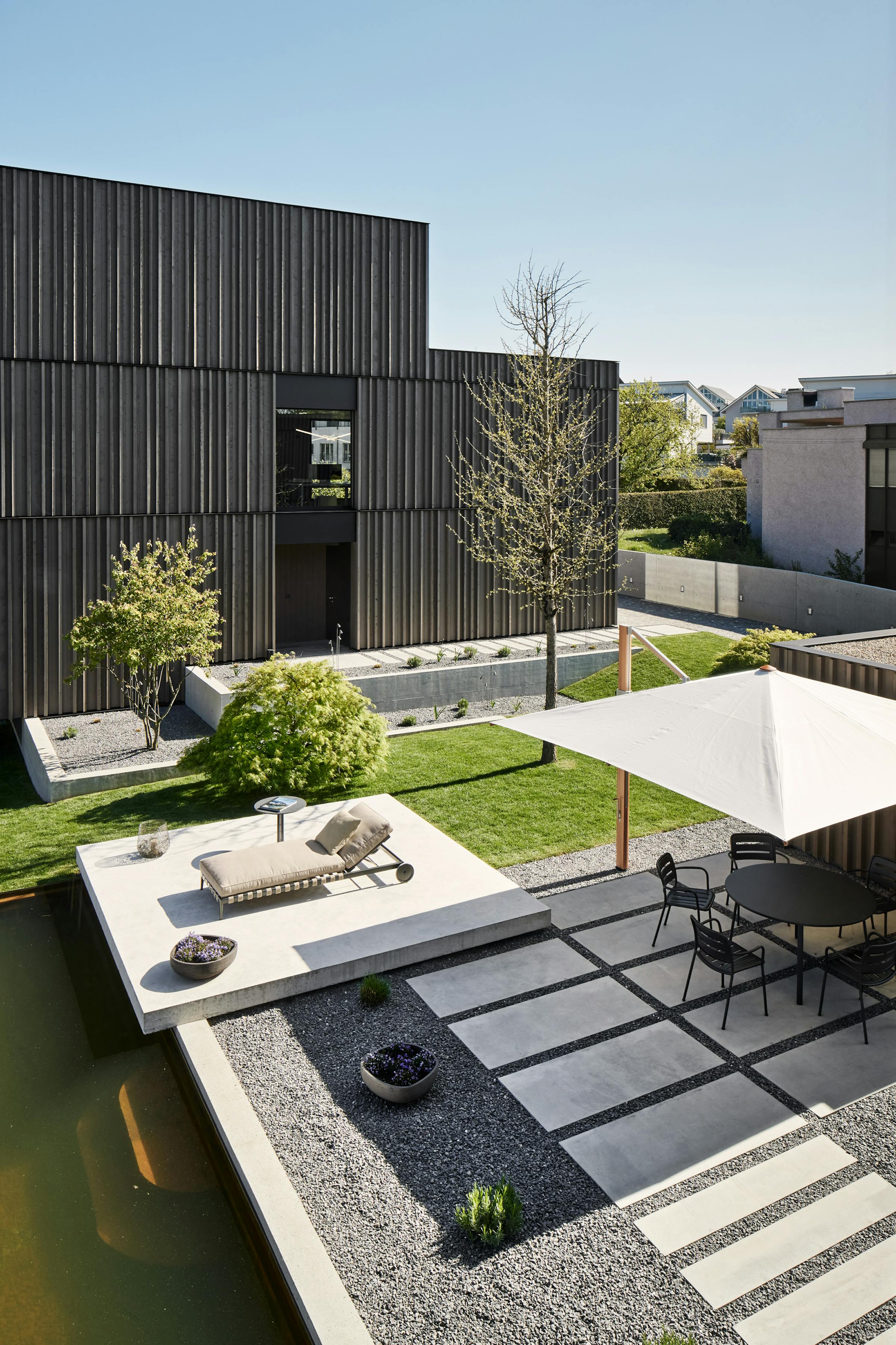 Courtyard of two buildings with a daybed and an outdoor table