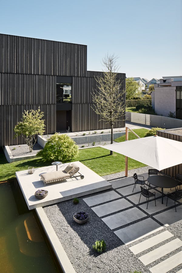 Courtyard of two buildings with a daybed and an outdoor table