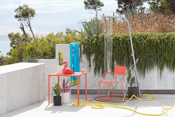 Orange outdoor chair under an outdoor shower on a terrace
