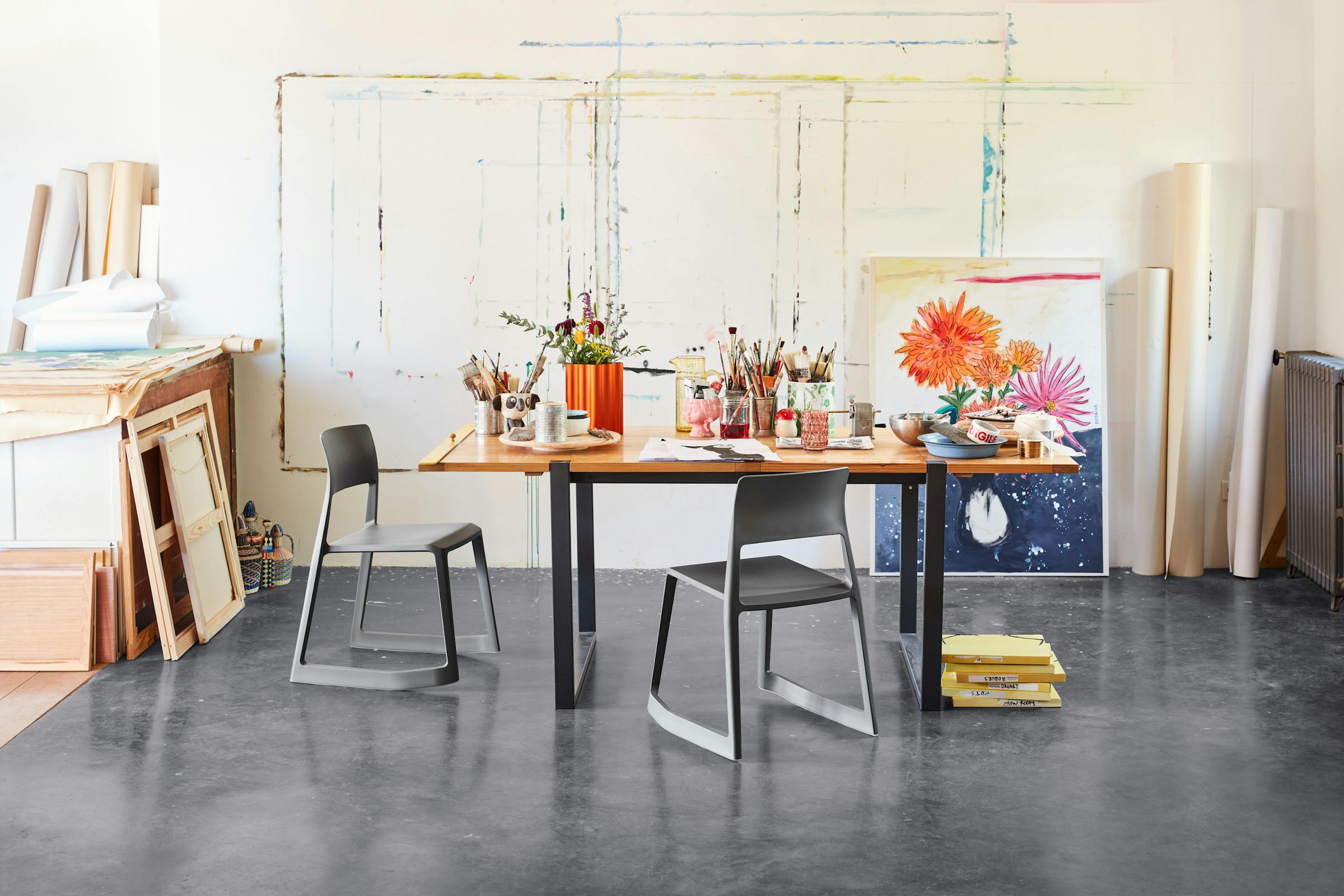 Table in an artist's studio with two TipTon chairs and several pencil holders on top