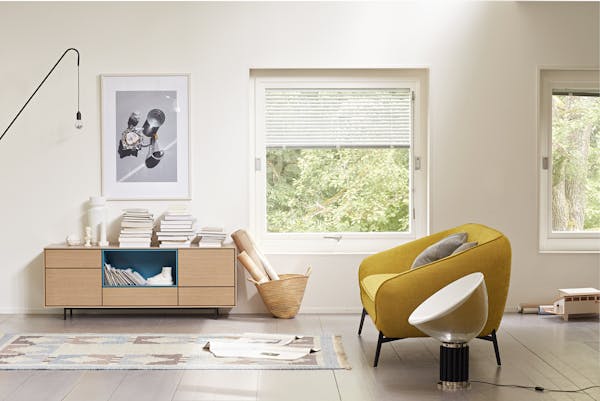 Yellow sofa with sideboard and lots of books in a living room