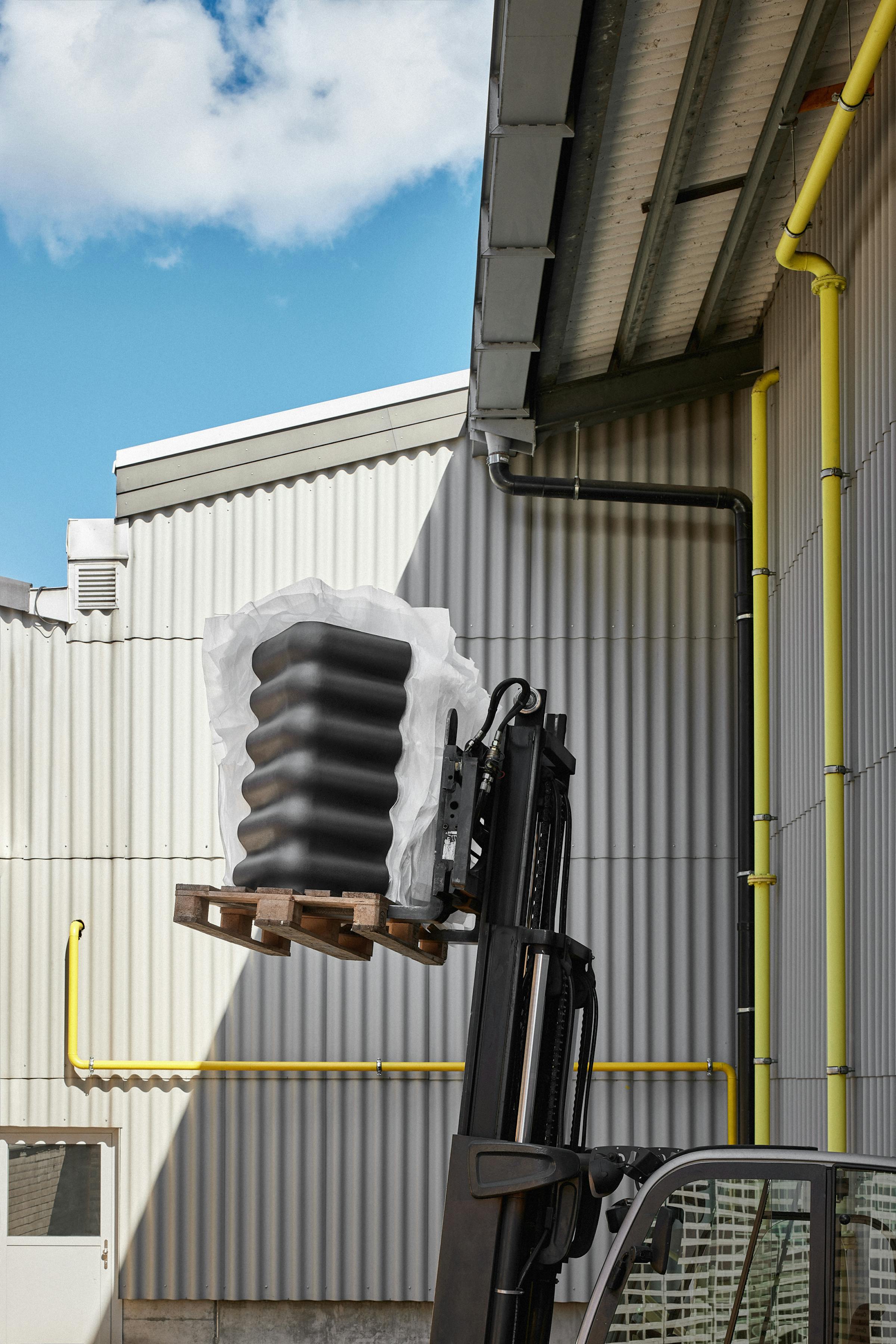 forklift truck with eternit poducts in front of an eternit wall