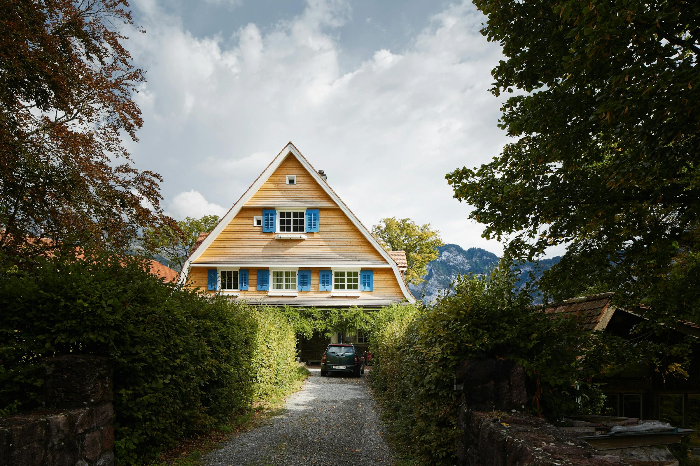 Front view of a 19th-century house with a pitched roof in the mountains