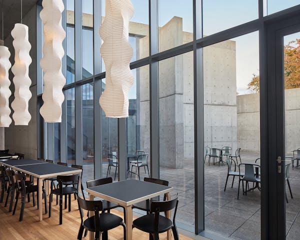 View from the Tadao Ando Pavilion at the vitra campus in Weil am Rhein  into the inner courtyard, long paper lights by Ismau Noguchi hang from the ceiling