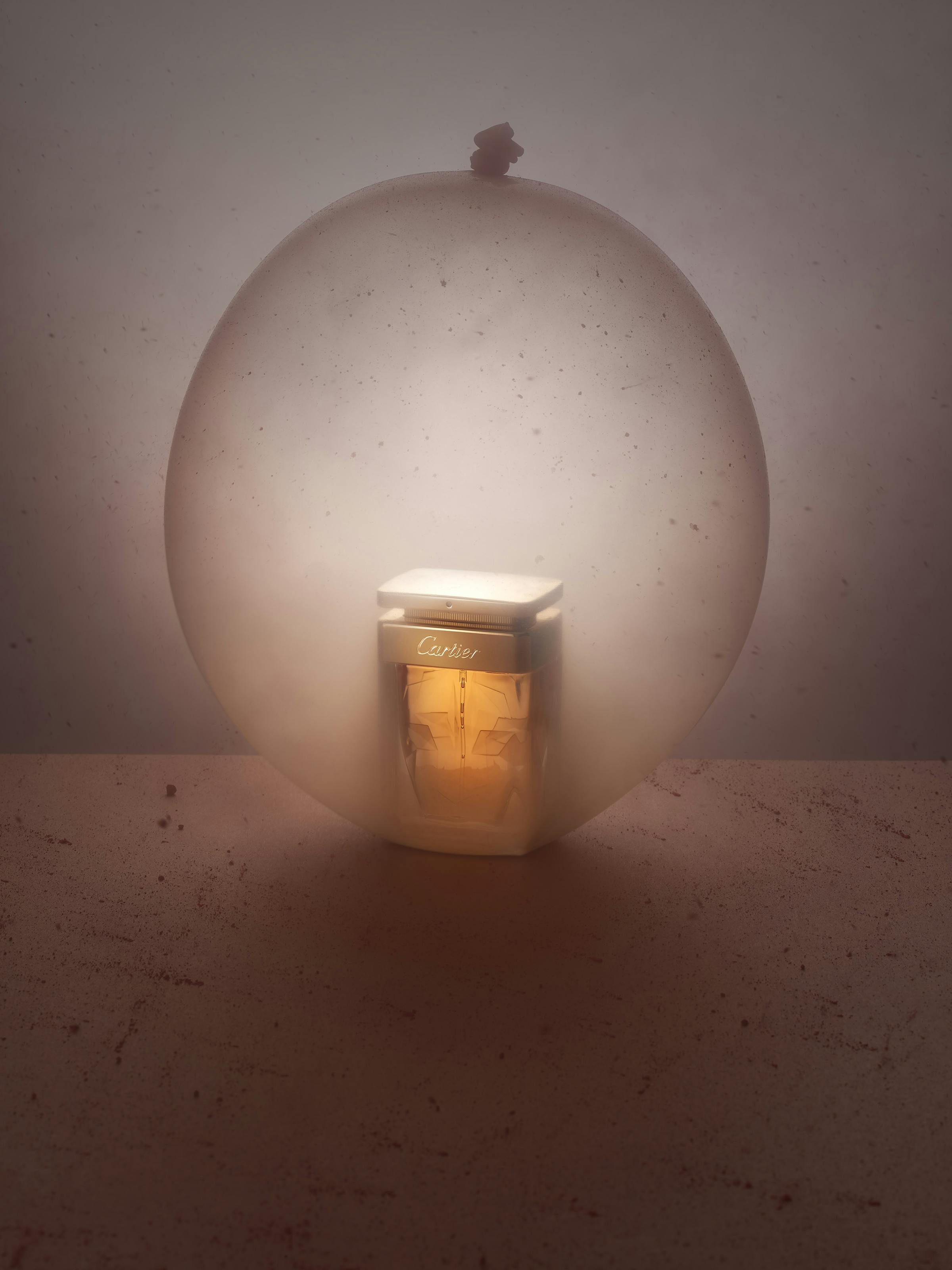 a Cartier perfume in a large nude-coloured balloon