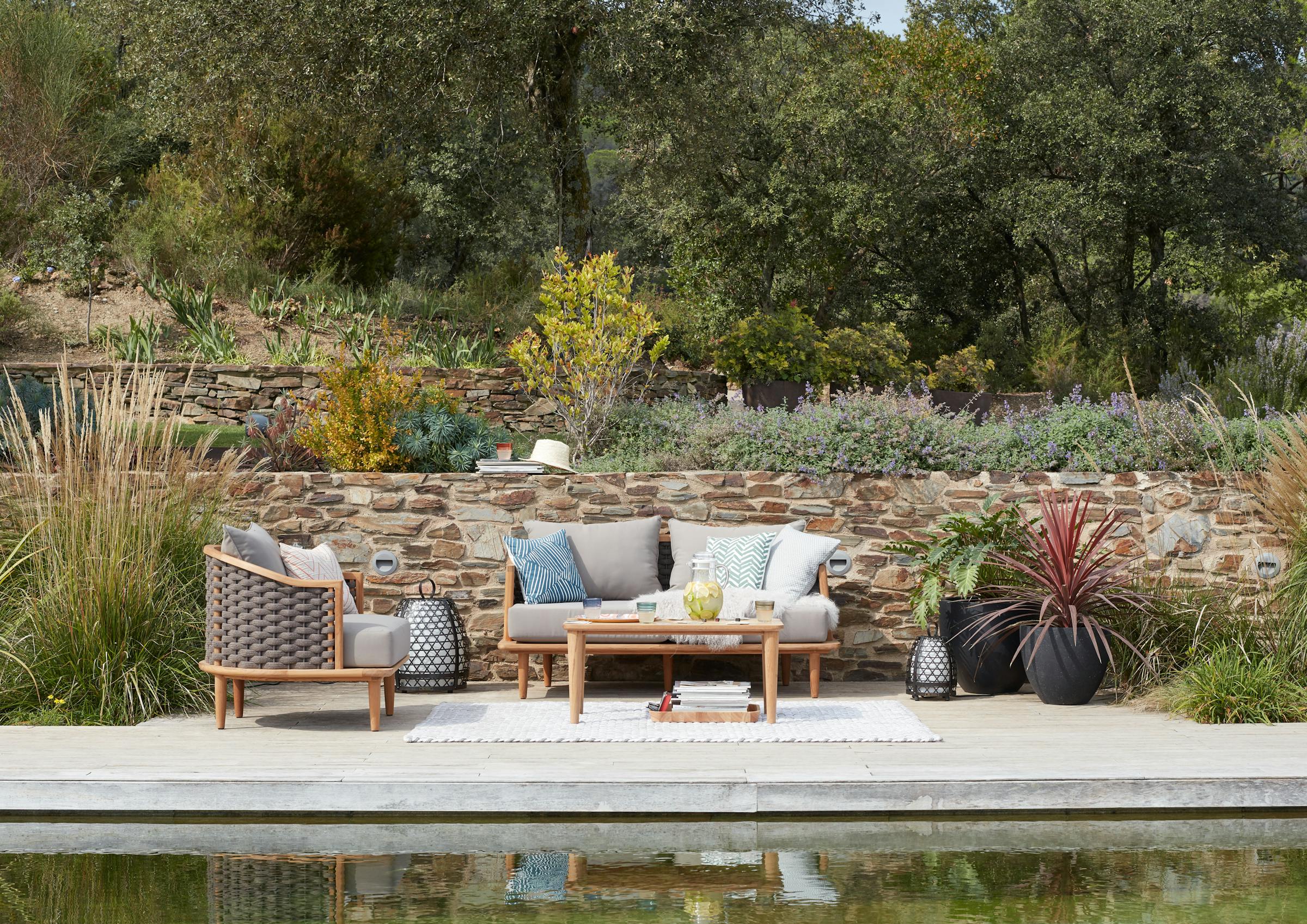 Outdoor sofa and armchair on a terrace by a swimming pool