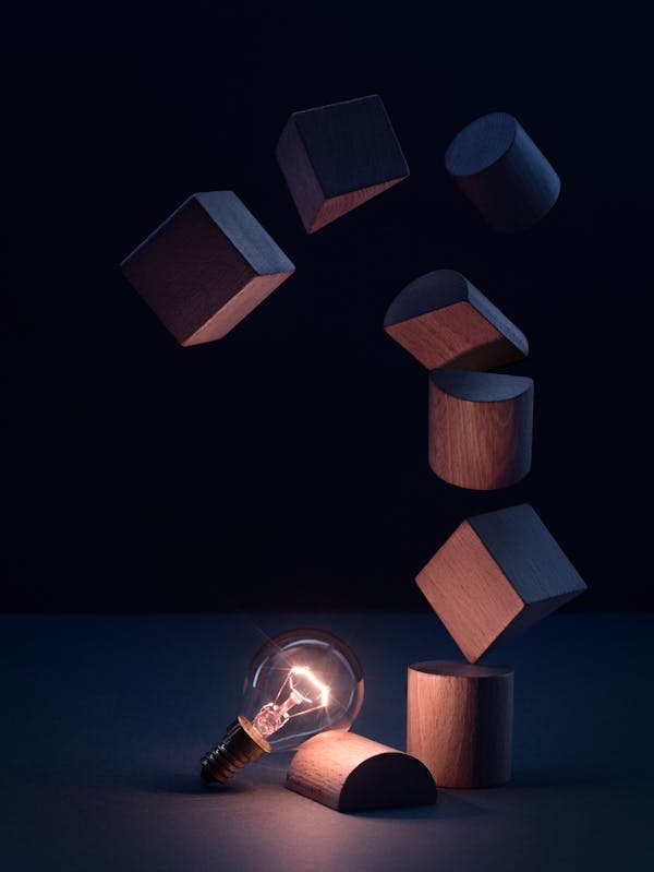 Light bulb with wooden building blocks in a dark blue set