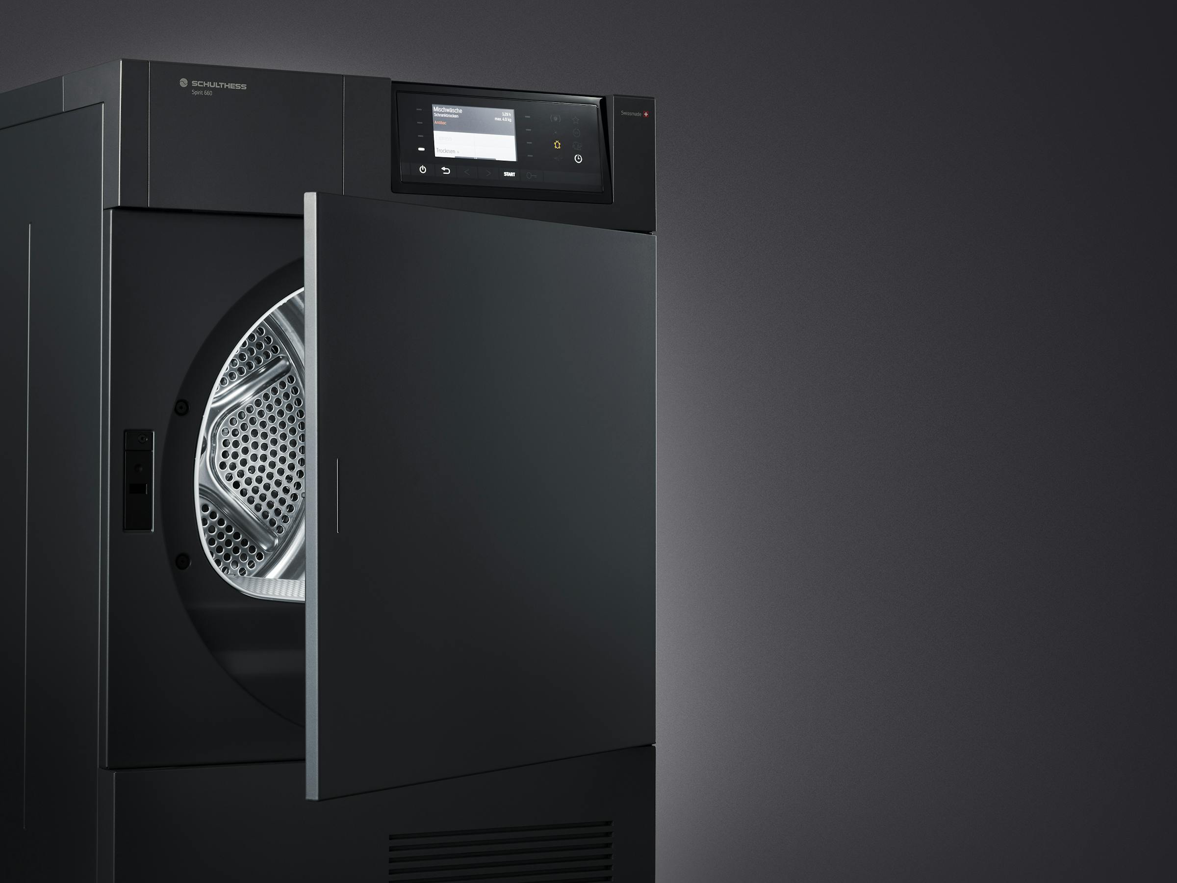 Close-up shot of a black tumble dryer in front of a black background with the door open