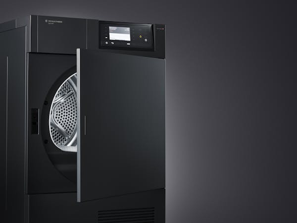 Close-up shot of a black tumble dryer in front of a black background with the door open